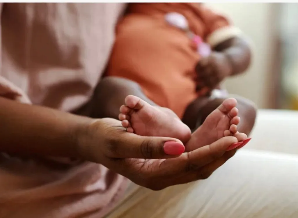 Postpartum care provider supporting a new mother and baby